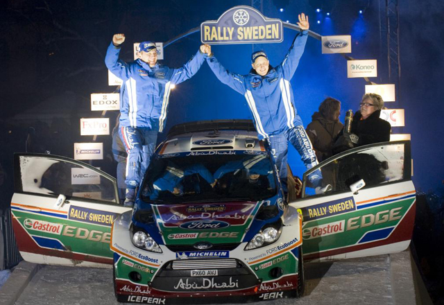 Hirvonen y su copiloto Lehtinen con el coche con el coche que les ha servido para ganar la primera prueba del Campeonato del Mundo de Rallies.