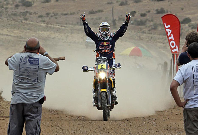 Marc Coma llega a meta levantando los brazos sobre su KTM.